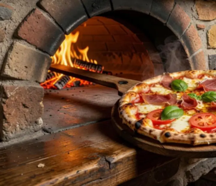 Close-up of a wood-fired pizza with golden crust and fresh toppings